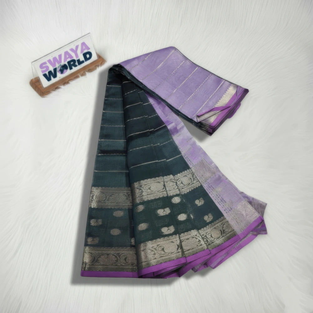 Two sarees, one green and one purple with silver patterns, on a white surface with 'Swaya World' branding.