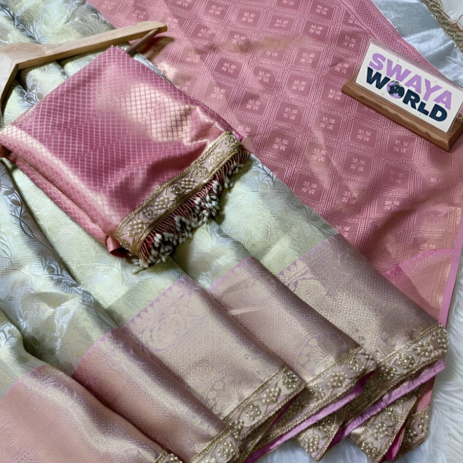 Pink saree with gold border on a pink fabric background, branded 'Swaya World'.