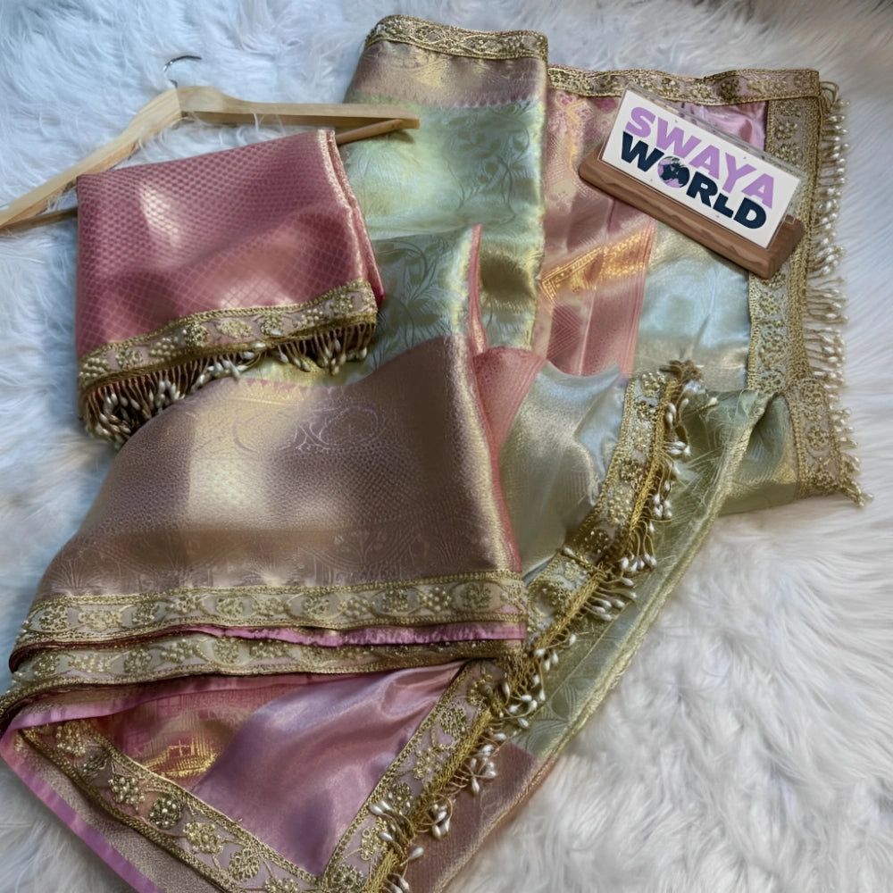 Pink and gold saree with a 'Swaya World' tag on a white surface