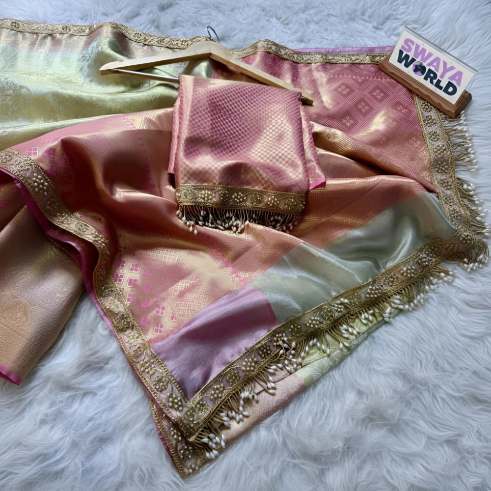 Pink saree with gold border on a white fur surface, branded 'Swaya World'.