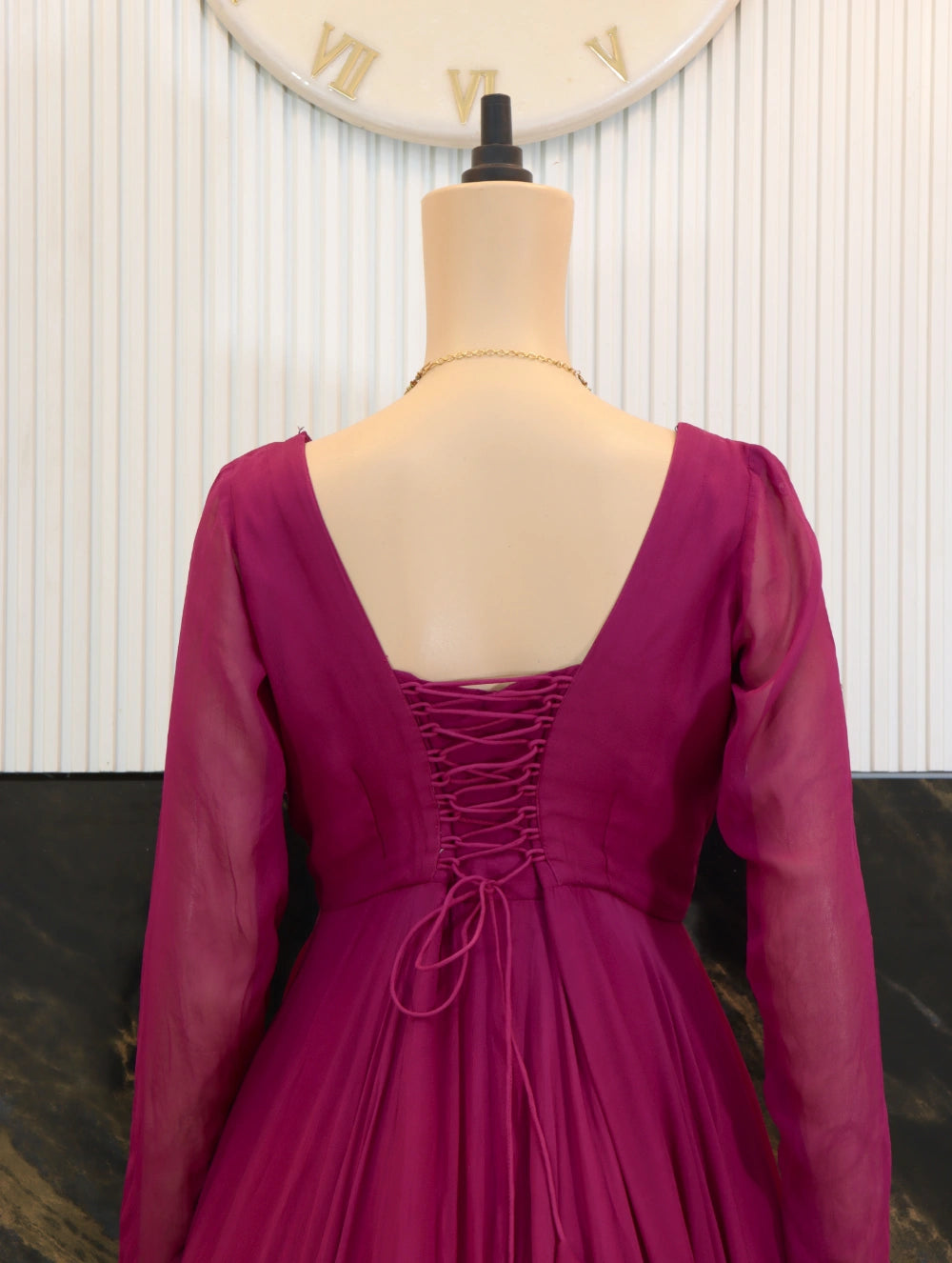 Back close view of Magenta georgette long frock with sheer sleeves, fitted bodice, and full flared skirt.