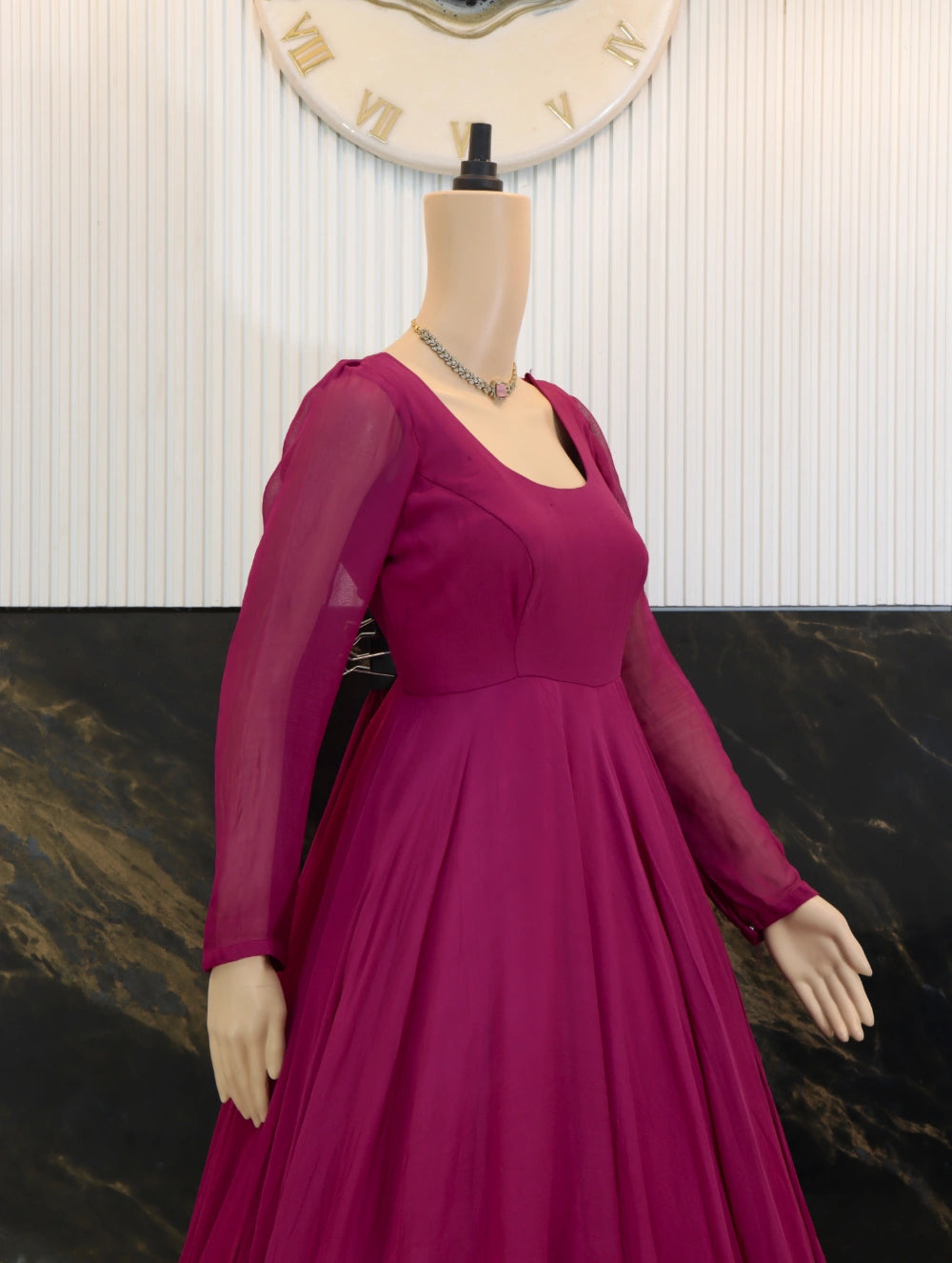 Close side view of Magenta georgette long frock with sheer sleeves, fitted bodice, and full flared skirt.