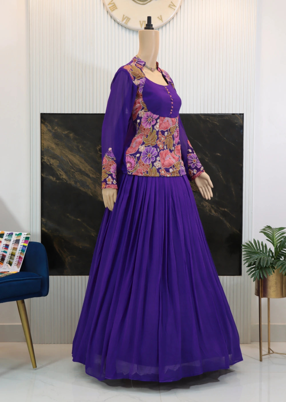 Side angle of purple designer outfit showing floral jacket over peplum top and flowing skirt