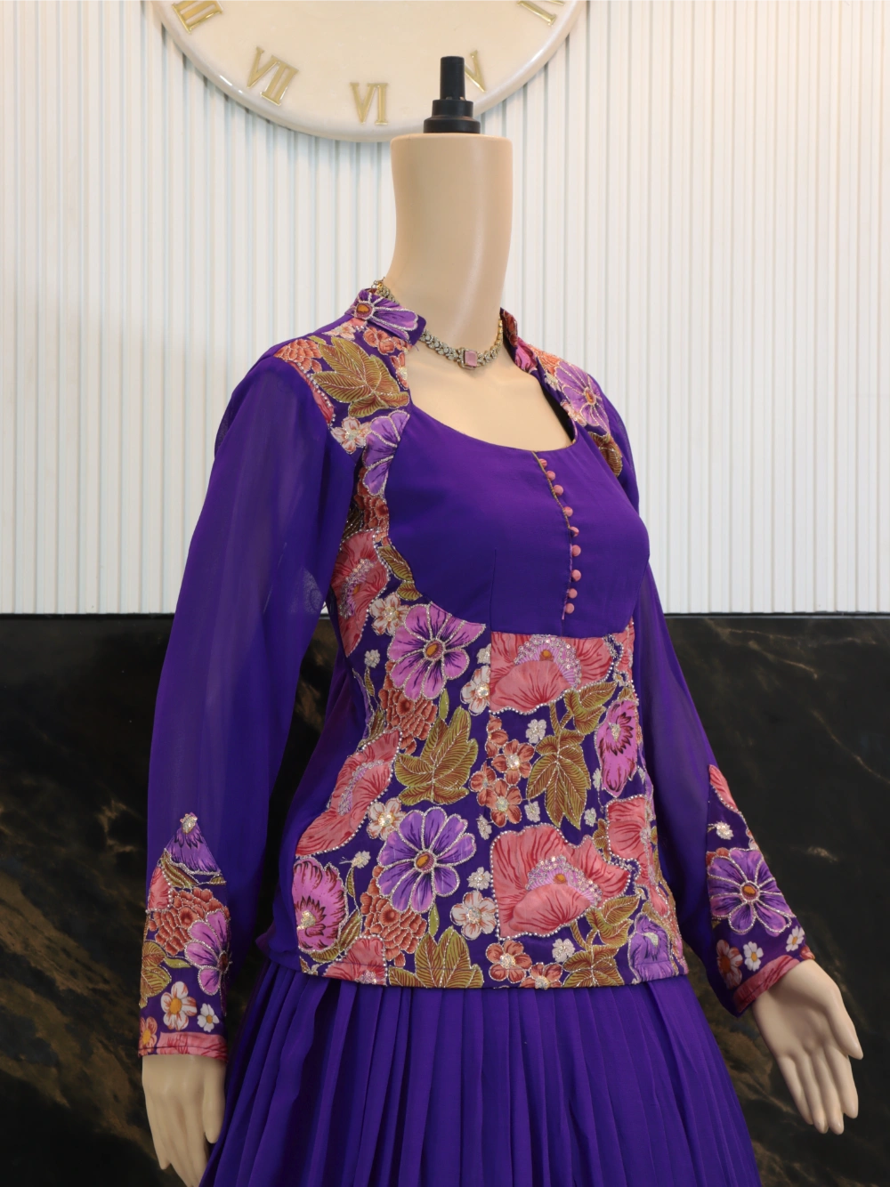 Close Side angle of purple designer outfit showing floral jacket over peplum top and flowing skirt